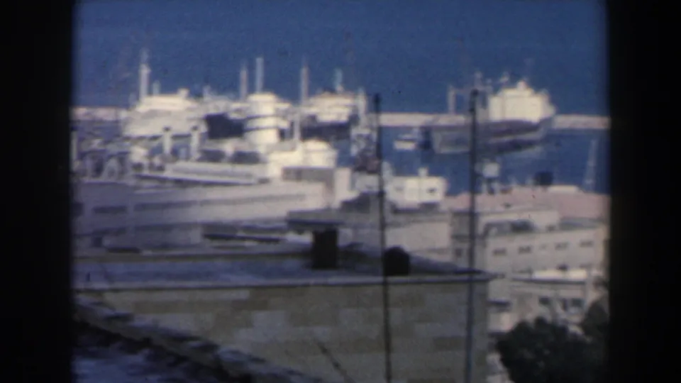 1960 Israel harbor footage showing large docked vessels, piers, cranes, and port buildings from an elevated vantage point.
