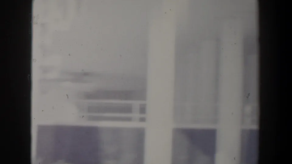Soft 8mm frame from Israel showing pale building columns and windows with heavy exposure and partial framing.