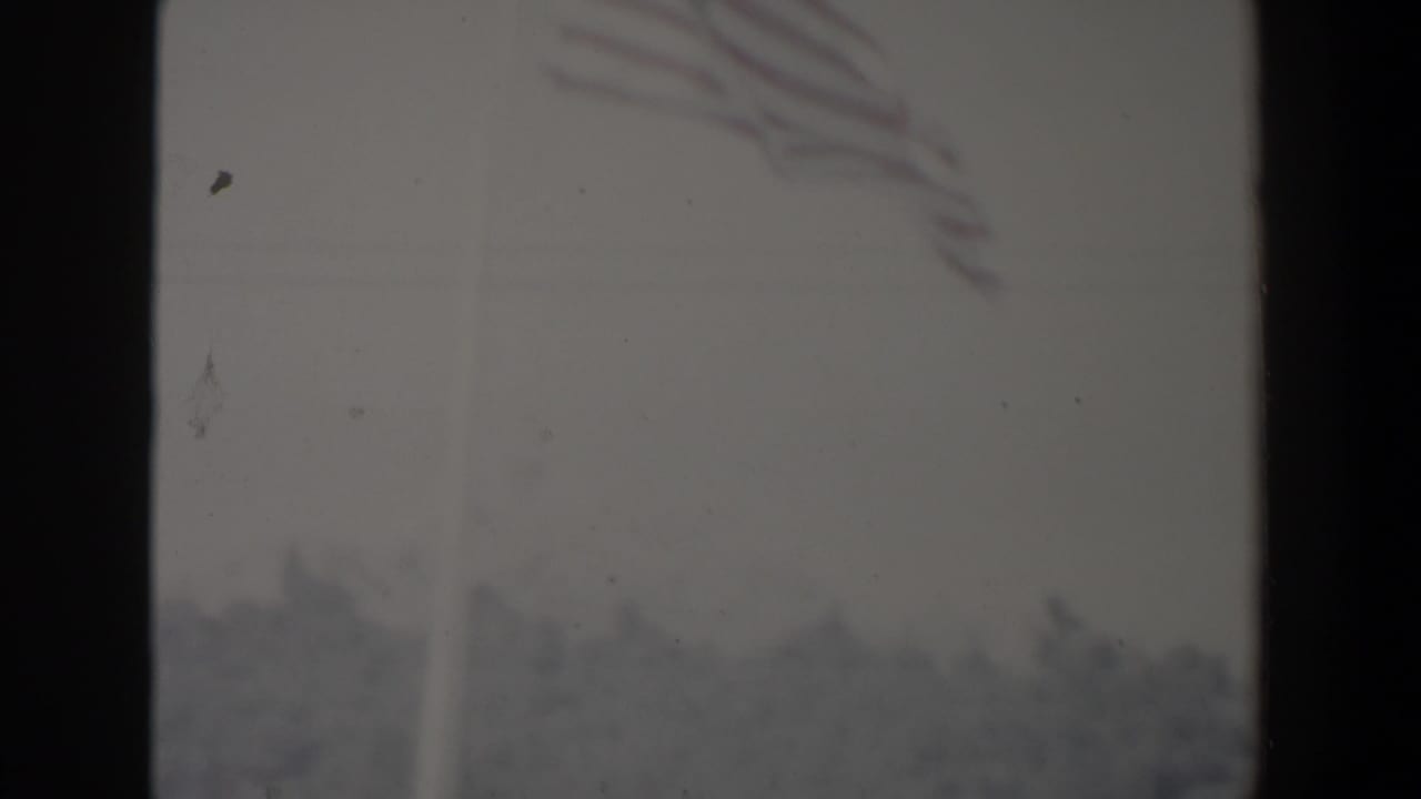 Foggy street or city view partly obscured by dark film-frame borders.