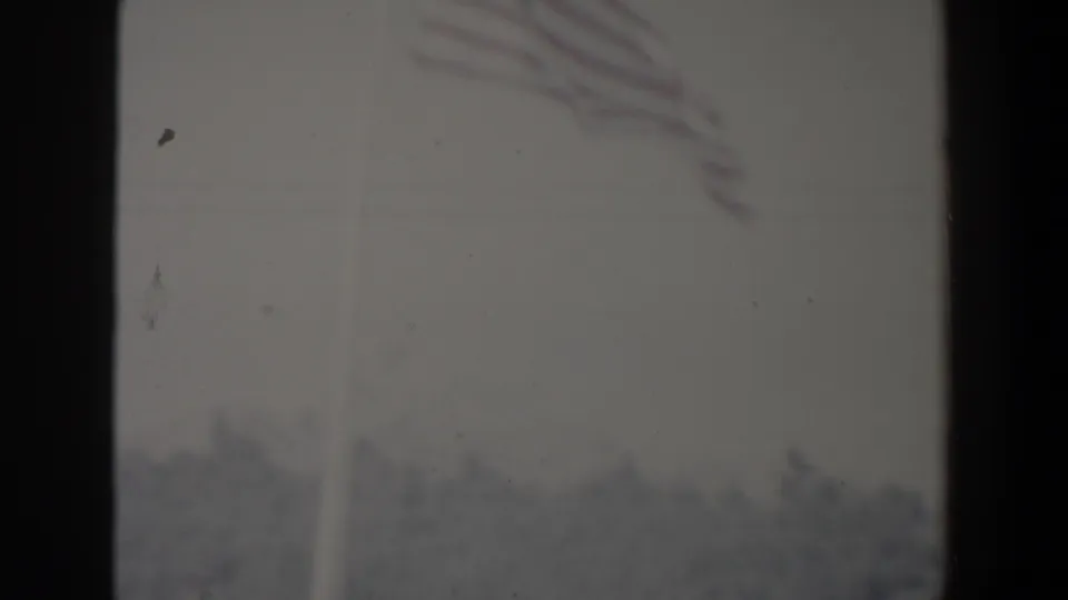 Hazy 1960 Israel home-movie frame with an indistinct street view seen through dark vertical borders and soft exposure.