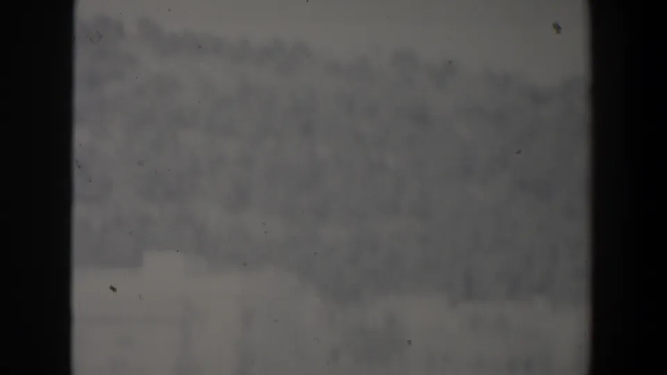 Soft, hazy 1960 Israel frame showing an indistinct outdoor city view between dark film borders.