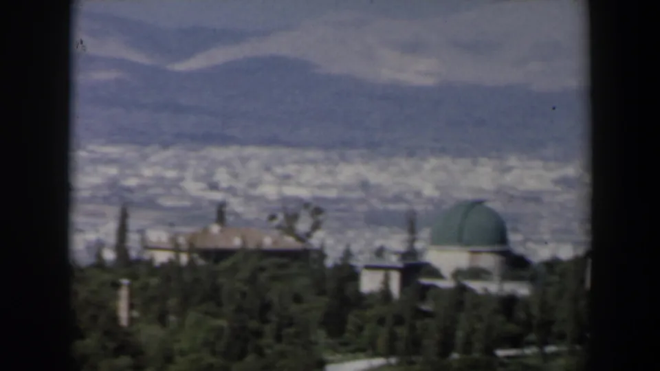 1960 Israel view of a green-domed building and surrounding trees before a broad urban panorama.