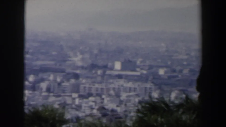 1960 Israel home-movie frame showing a soft, distant city view and hazy horizon from an elevated vantage point.