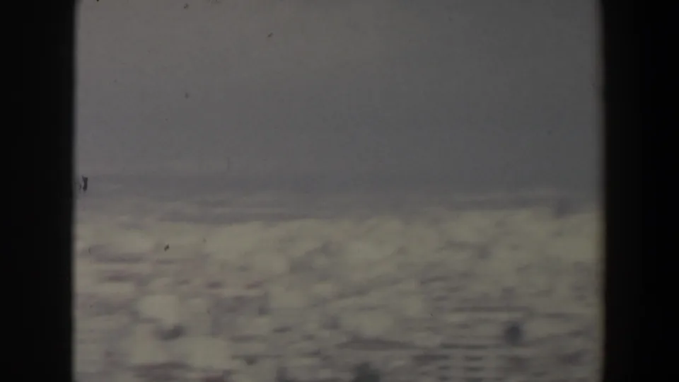 Snowy mountain terrain in Israel appears through soft 8mm focus, with a dark vertical foreground band crossing the frame.