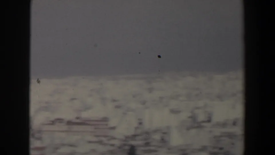 A 1960s Israel winter view shows a pale snow-covered valley floor beneath gray sky, with dark foreground edges from the camera position.