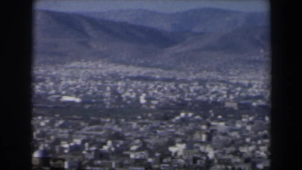 1960 Israel 8mm frame showing a broad daylight city view, distant mountains, and the soft grain of home-movie film.