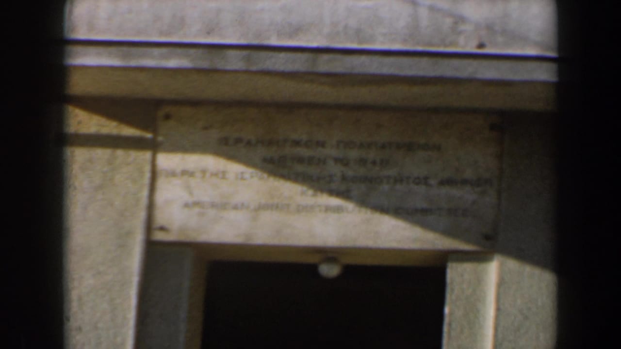 Stone plaque above a shadowed doorway on a sunlit building facade.