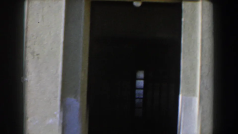 1960 Israel 8mm frame showing the doorway and surrounding stonework of the monument site, with the plaque partly out of frame.