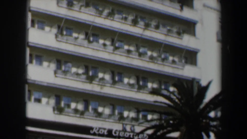 1960 Israel hotel facade with repetitive balconies, windows, and planter boxes seen in soft 8mm color.