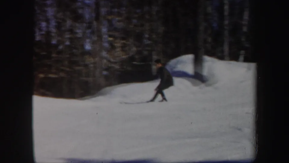 The skier appears to turn on a snowy Vermont slope, framed by bare woods and the rounded edge of the 8mm frame.