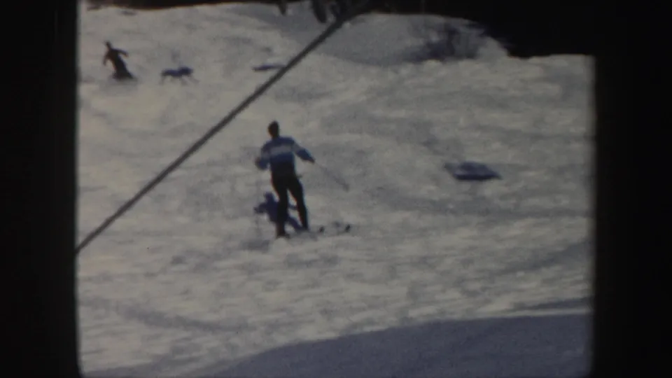 A man skis away across the Vermont snow, small in frame, with diagonal shadowing and soft 8mm exposure.