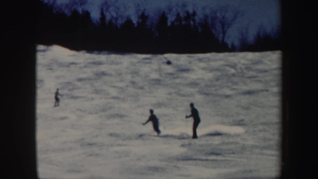Three distant skiers move across a snowy Vermont slope in this 1962 8mm home-movie frame.