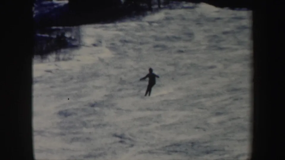A single distant skier crosses the snowy Vermont slope in a soft, grainy 1962 home-movie frame.