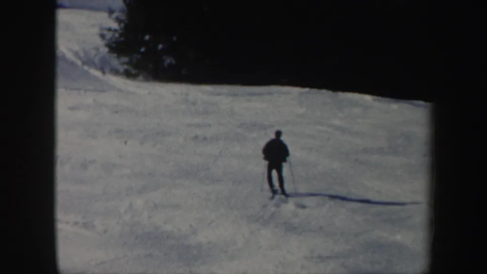 The skier stands on the snow-covered Vermont slope after the fall, framed at a distance in 1962 home-movie footage.