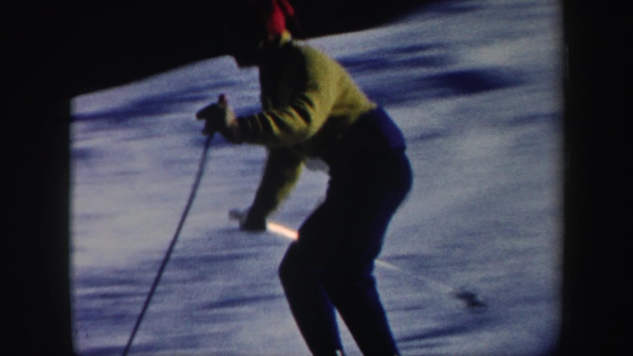 Close handheld view of the skier leaning into motion with poles on a snowy Vermont slope, 1962.