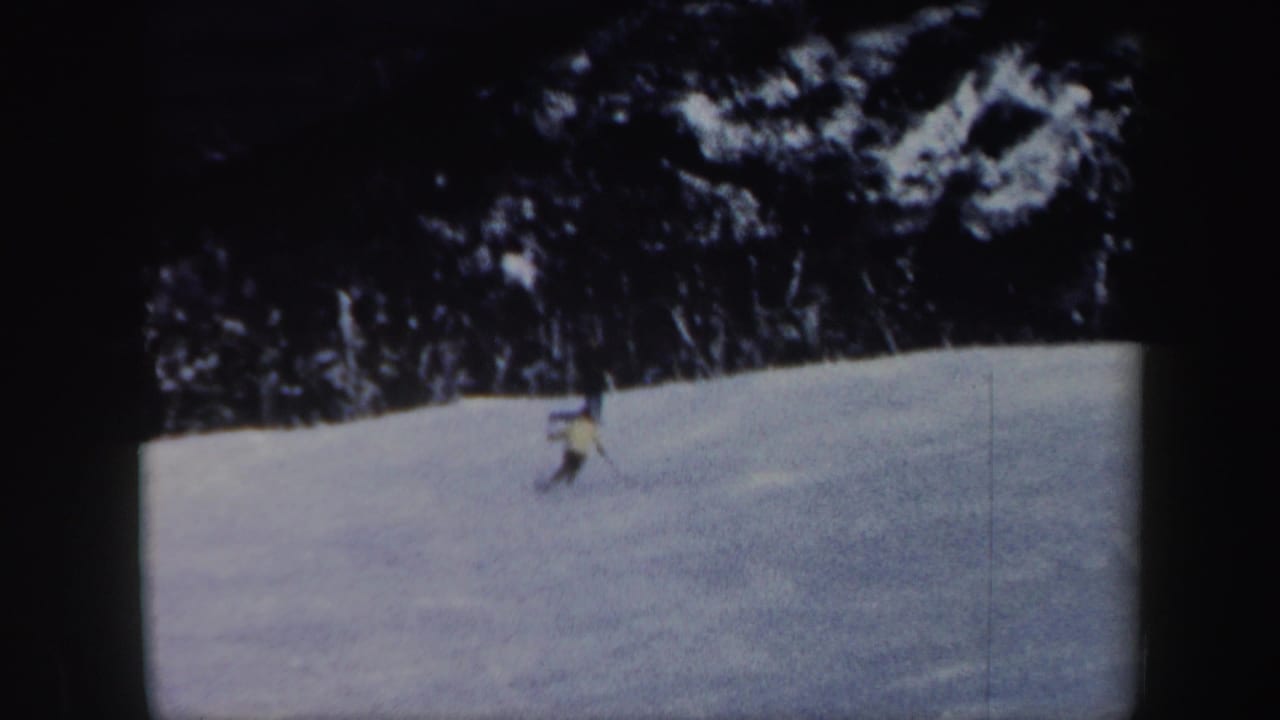 Distant skier continues across a Vermont snow slope in grainy 1962 8mm home-movie footage.