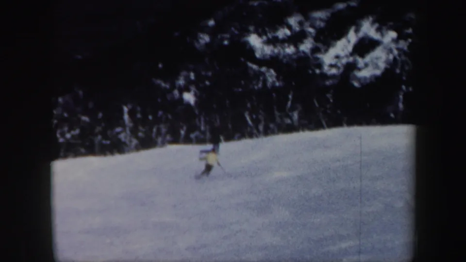 Distant skier continues across a Vermont snow slope in grainy 1962 8mm home-movie footage.