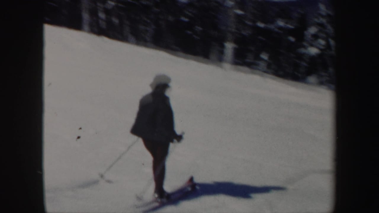A woman skier appears in profile on a bright Vermont snow slope, with poles and a long shadow visible.