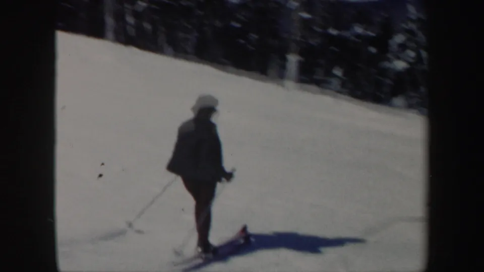 A woman skier appears in profile on a bright Vermont snow slope, with poles and a long shadow visible.