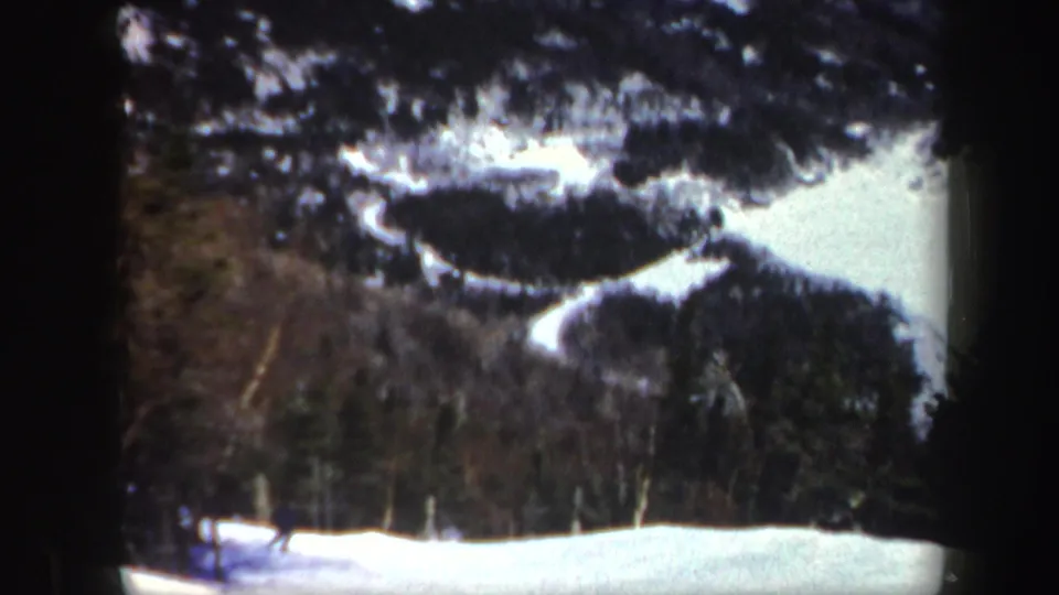 The final frame holds the wooded Vermont snow slope, with the skier small near the edge of the 8mm frame.