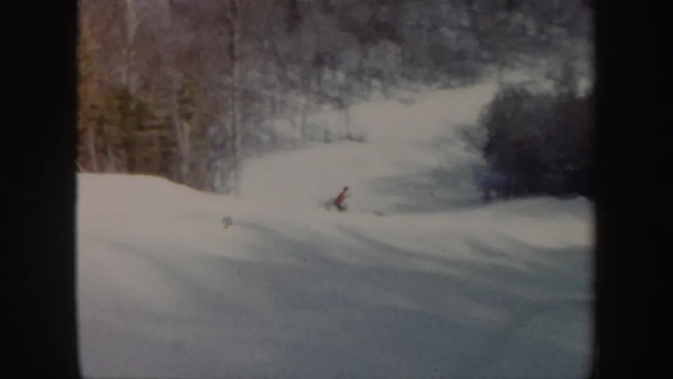 The skier glides through an open snowy run framed by Vermont woods in 1962 home-movie footage.