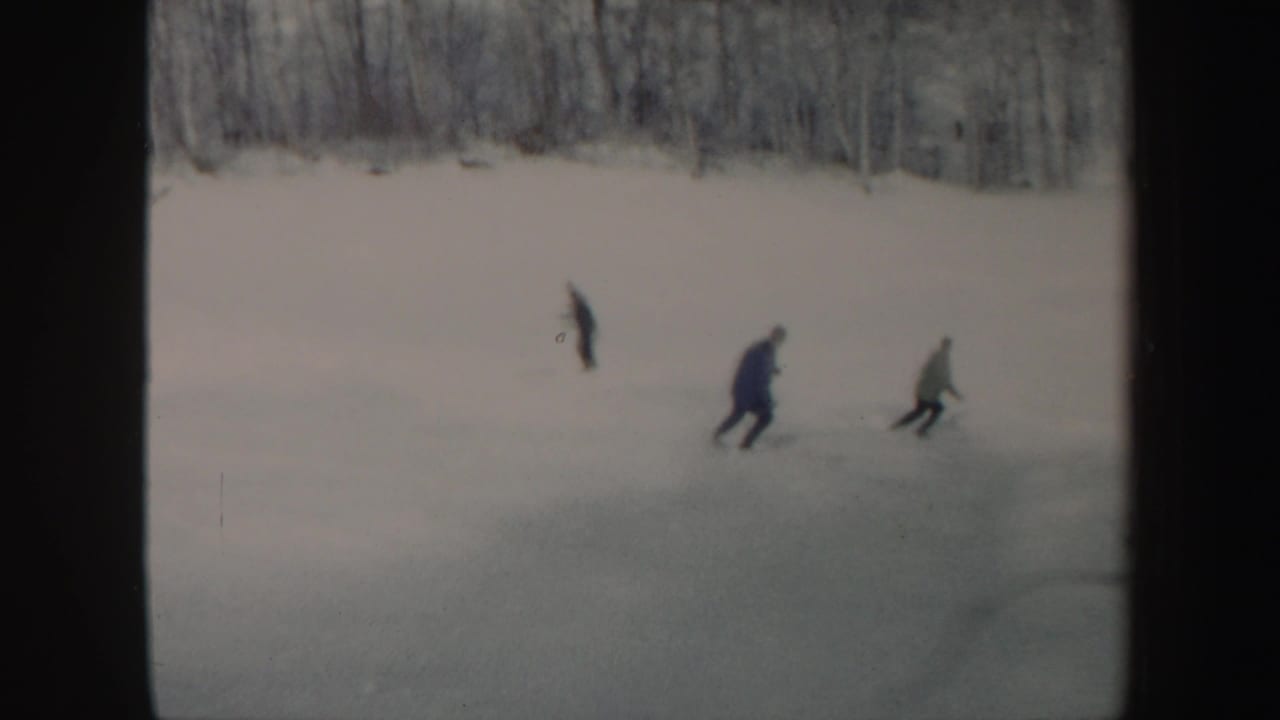 Three skiers in winter clothing move across a snowy Vermont slope in 1962 home-movie footage.