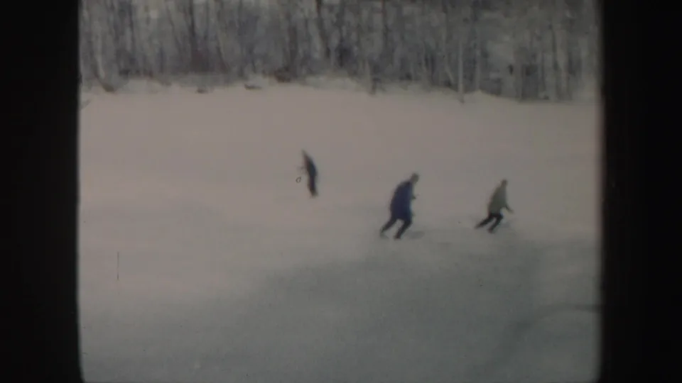 Three skiers in winter clothing move across a snowy Vermont slope in 1962 home-movie footage.