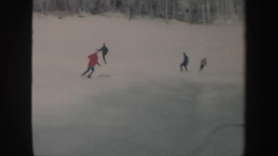Multiple skiers traverse the snowy Vermont hillside, with a red-jacketed figure prominent at left.