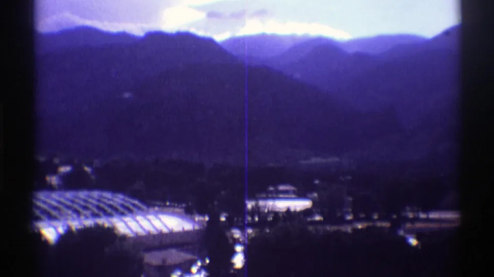 1969 Colorado 8mm view across mountain slopes, with the domed structure partly visible at lower left and small buildings below.