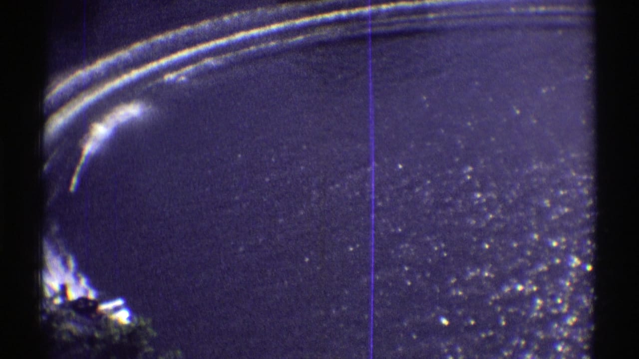 Speedboat wake on a dark blue lake with film-frame borders.