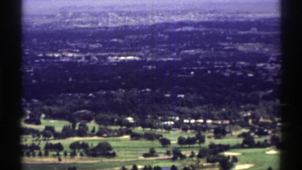 Colorado 1969 8mm frame showing a soft, grainy overlook of a golf course and distant suburb.