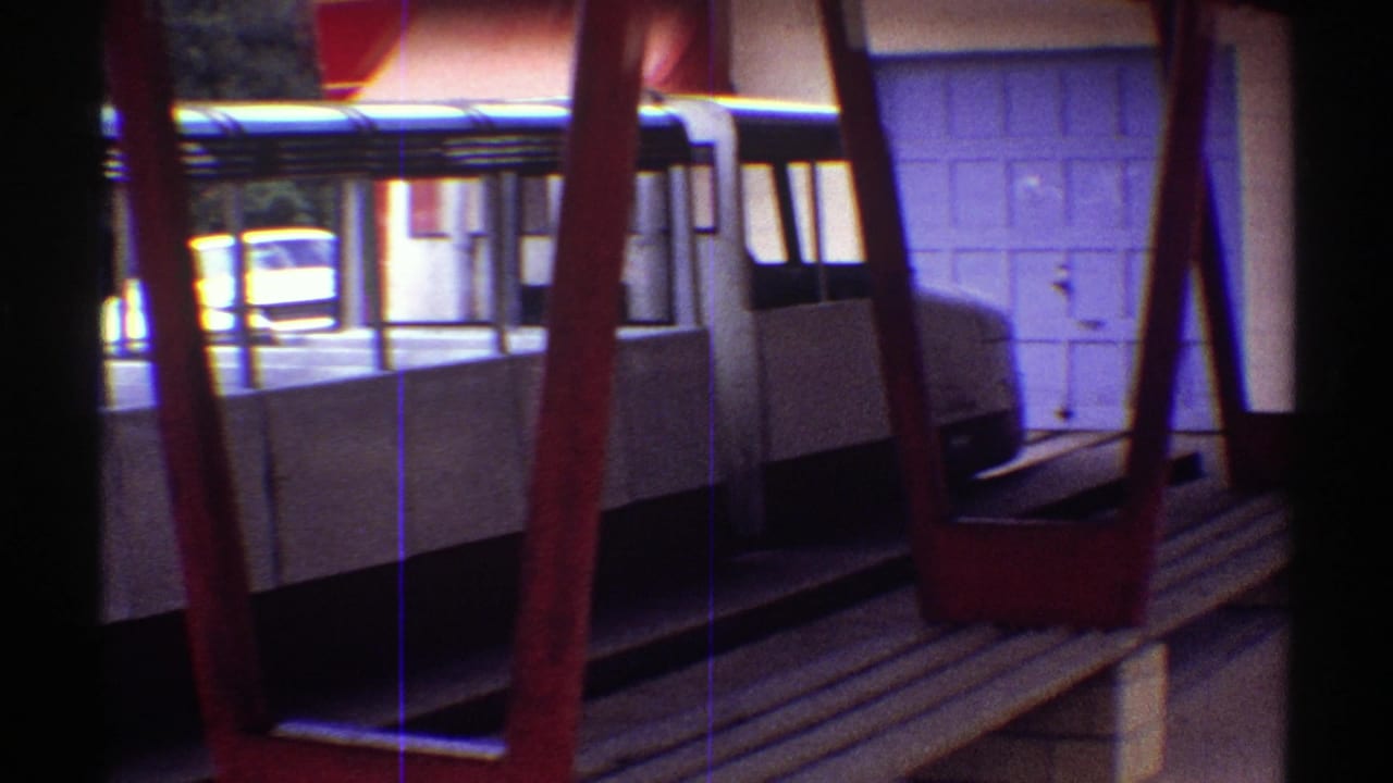 Open shelter seating with white cloth over benches, red posts, and a car in the background.