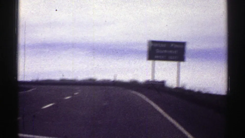 Colorado highway POV as the car passes the Raton Pass Summit next-exit sign on the right shoulder.