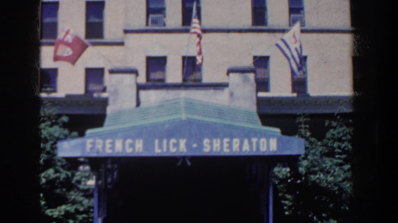 Blue French Lick-Sheraton awning and flags appear against the beige hotel facade in French Lick, Indiana, 1958.