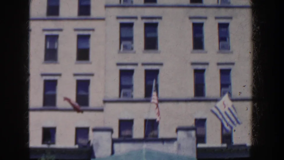 The camera frames the French Lick-Sheraton facade, showing rows of windows, flags, and the awning edge in 1958 footage.