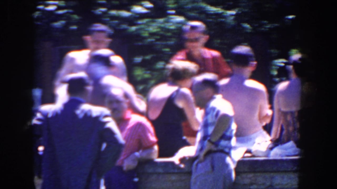 A closer 1958 French Lick view shows adults in bathing suits and casual shirts socializing beside a stone pool edge.