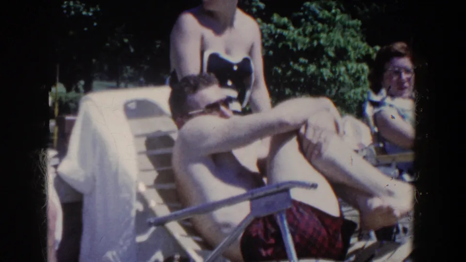 Adults in swimsuits lounge and sit near outdoor chairs during a sunny 1958 resort gathering in French Lick, Indiana.