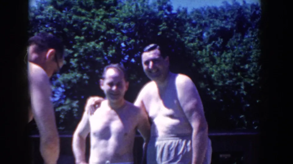 Poolside 8mm frame from French Lick with two men posing together and another adult partly visible in the foreground.