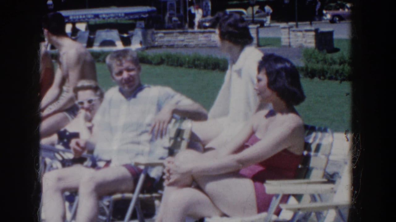 Adults relax in lawn chairs at French Lick, Indiana, with a woman in a red swimsuit and men in casual shirts visible.
