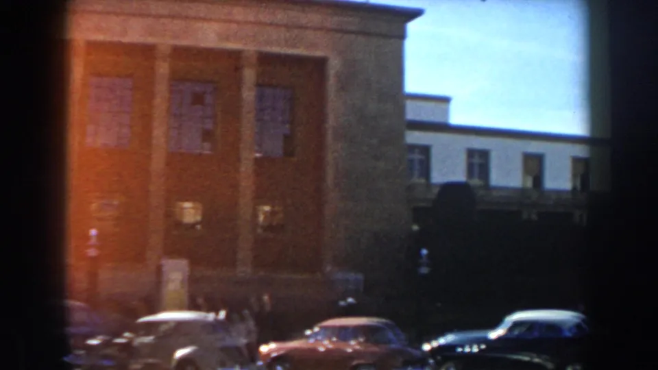 Casablanca street scene with brick and pale multi-story buildings behind parked 1950s cars.