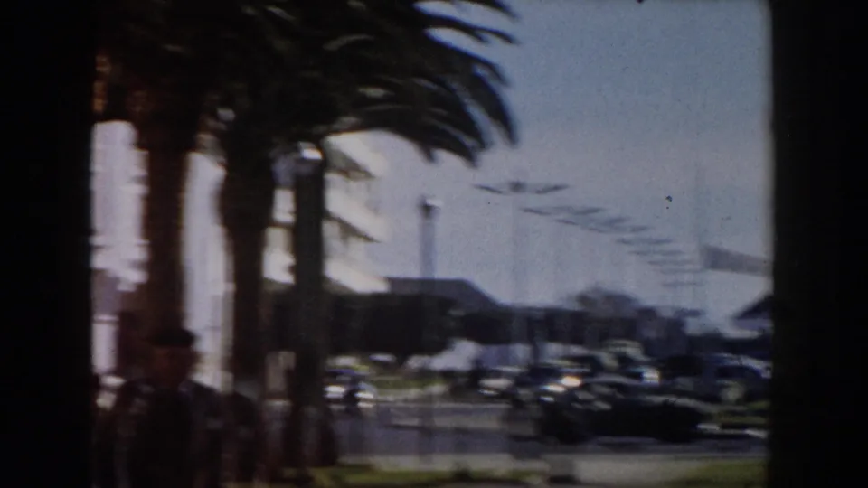 The final frame shows a bright palm-lined Casablanca street with mid-century cars and white facades in soft home-movie focus.