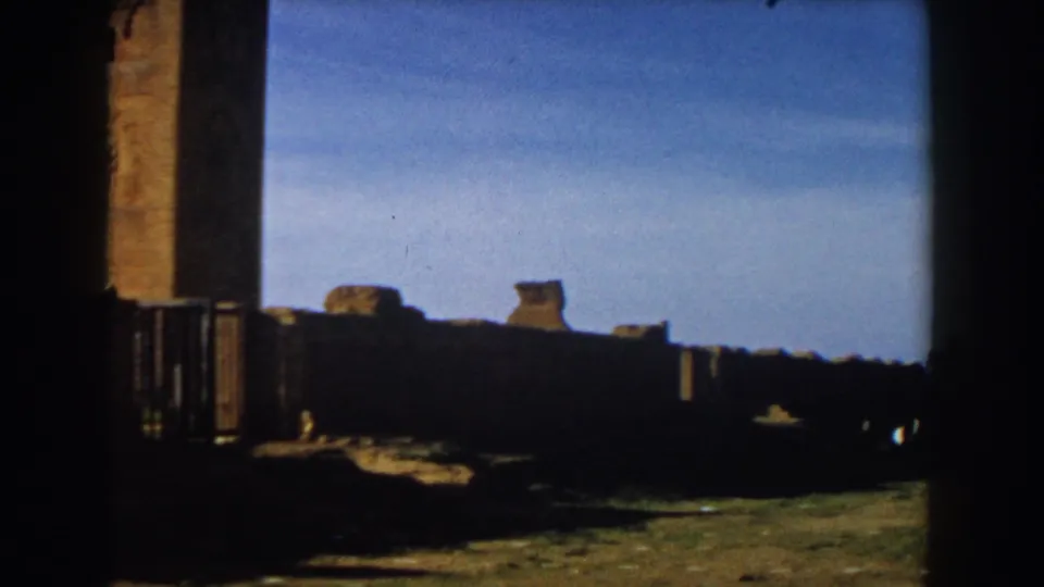 1959 Casablanca home-movie frame showing stone ruins and a tall tower seen through a dark foreground edge.