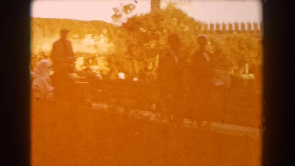 Warm 8mm frame of Casablanca garden visitors, with figures partly silhouetted by strong sunlight.