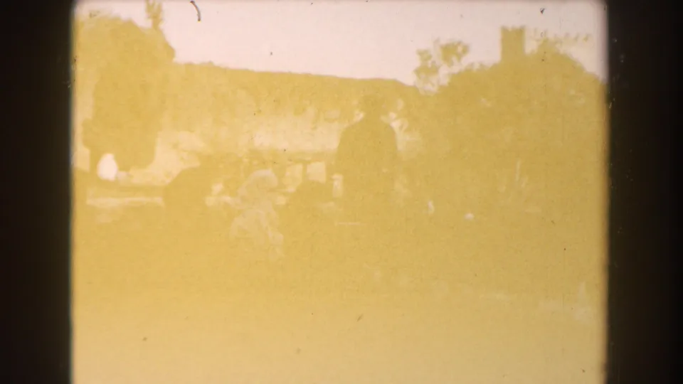 Overexposed 1959 Casablanca garden view with visitors faintly visible near trees and a stone wall.