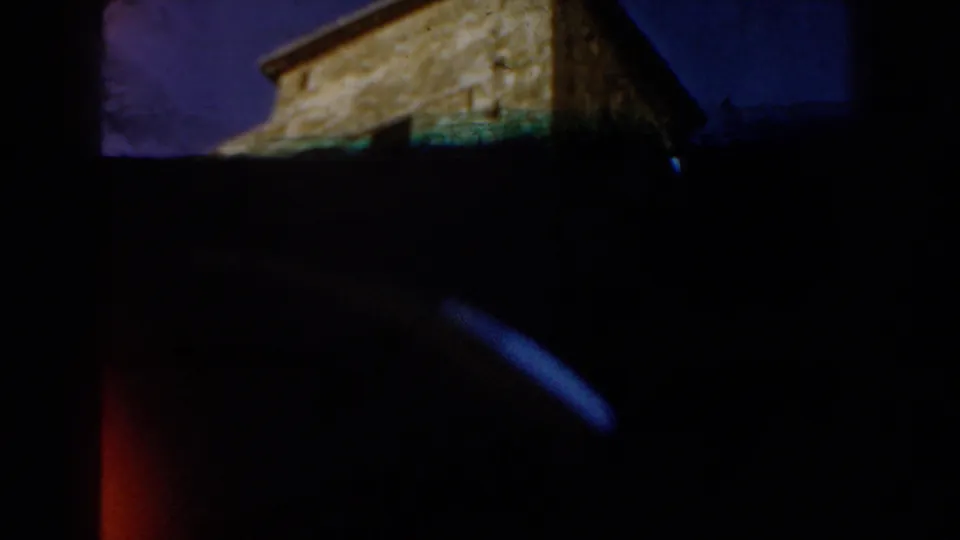 Underexposed 1959 Casablanca home-movie frame showing the stone structure from below with a dark foreground and sky above.