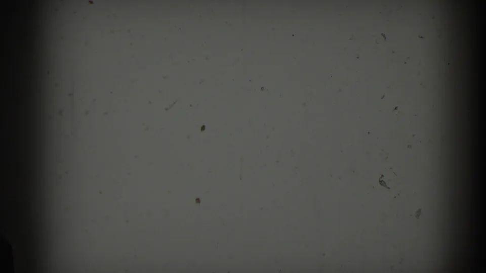 1959 Casablanca 8mm frame showing a grey overexposed field, scattered dust, small scratches, soft vignetting, and dark film-gate edges.