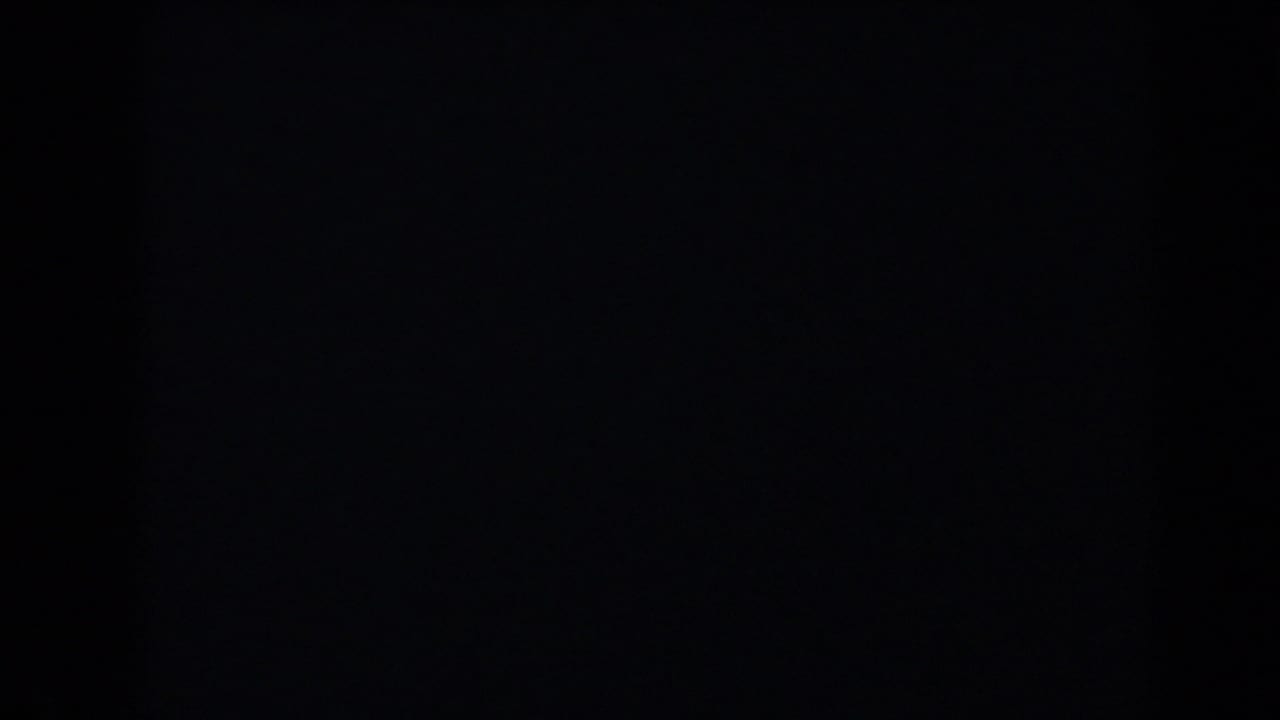Dark frame with a dim gray upper area and indistinct vertical shadow.