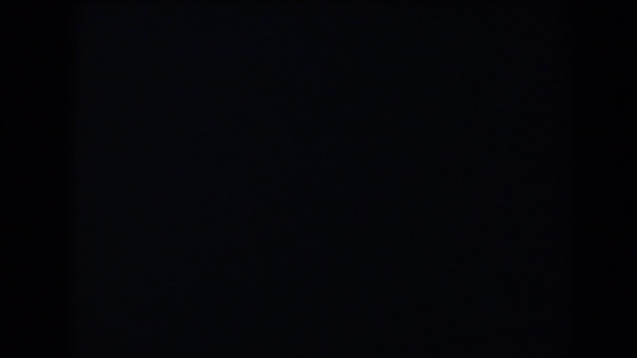 Very dark frame with faint vertical banding and minimal visible detail.