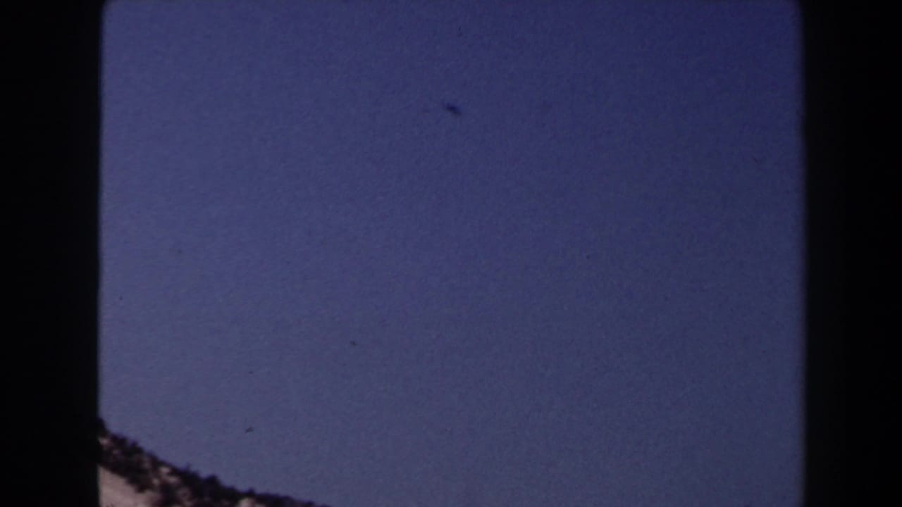 Las Vegas-area desert sky and partial rocky slope in faded 1958 8mm home-movie footage.
