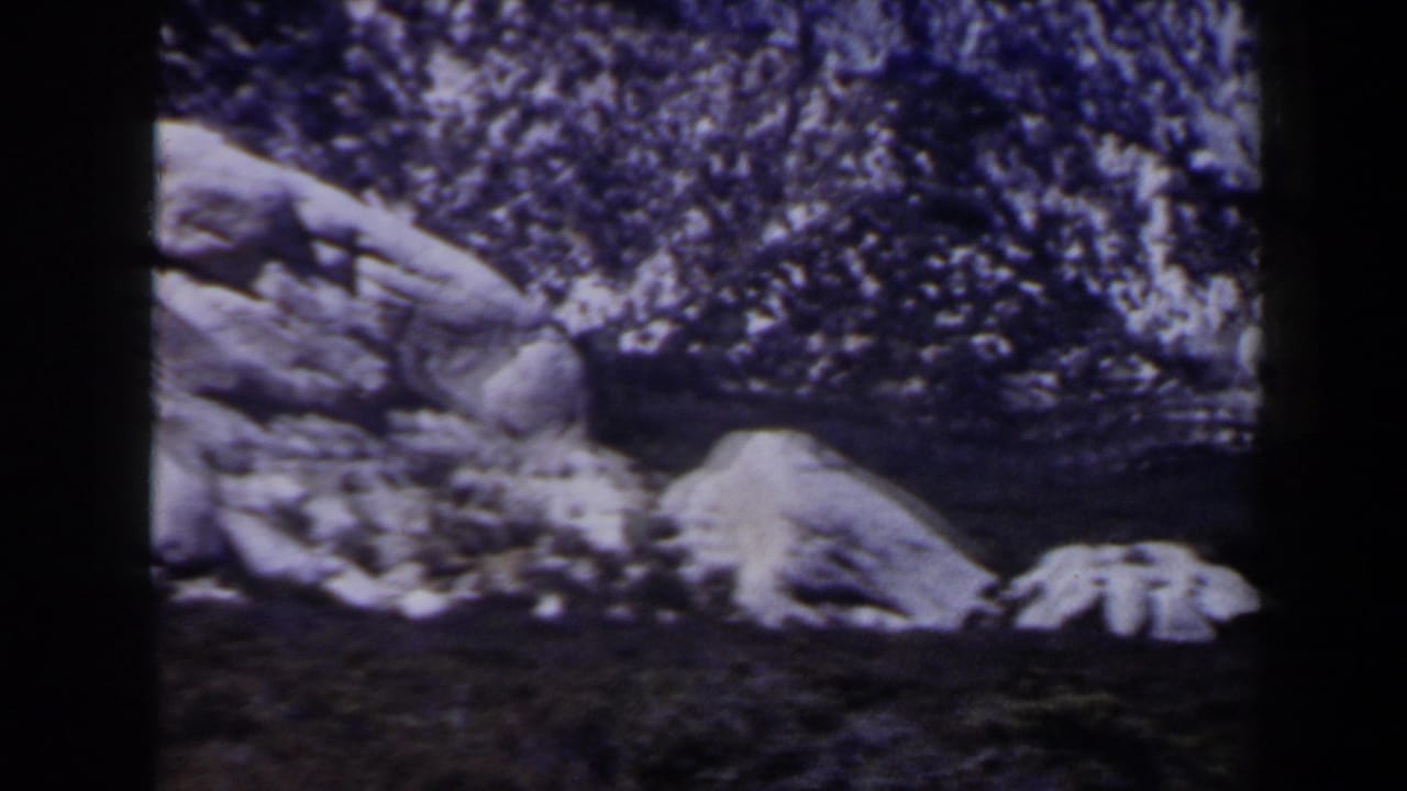 Aged 8mm view of rocks and lingering snow on rugged terrain, with the Las Vegas-area location supported by clip metadata.